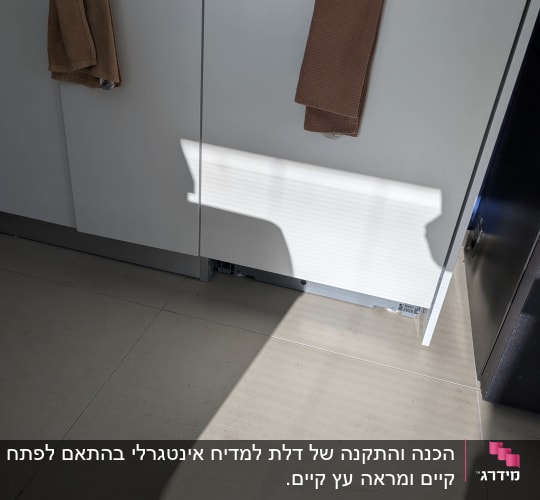 ארונות מטבח תחתונים בגימור לבן עם ידיות כסופות וצוקל בתחתית